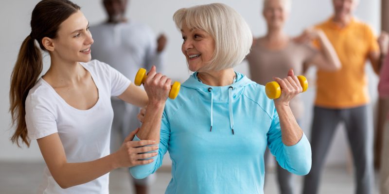 Female,Fitness,Coach,Helping,Active,Senior,Woman,While,Exercising,With
